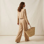 A different brunette woman, mid-length wavy hair, natural makeup, 

slim build, holding a woven straw tote bag, minimalist studio 

background warm off-white, soft diffused lighting, high-end fashion 

editorial style, photorealistic, high resolution, different person 

than reference, random natural pose, unexpected angle, 

use other pose for every photo