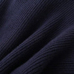 Close-up of a navy blue ribbed knit fabric, showing its soft texture and folds.