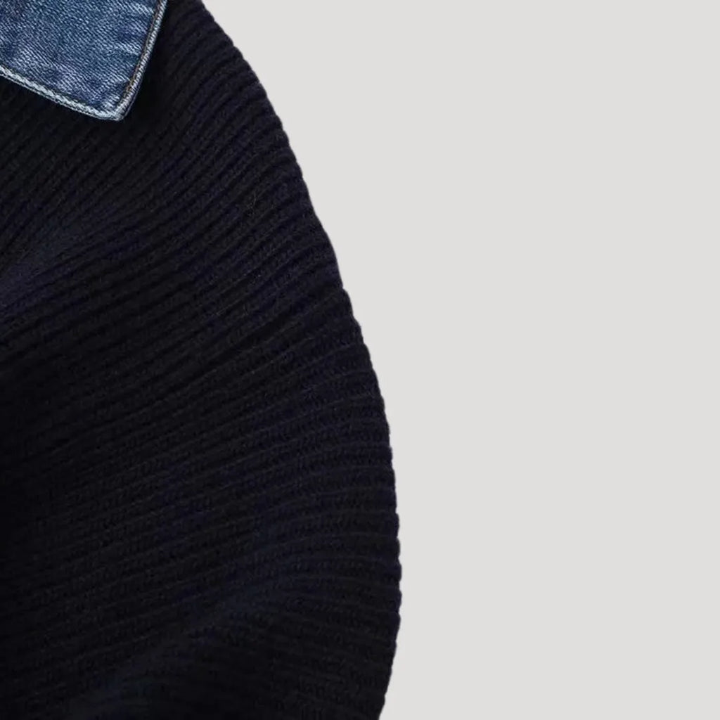 Close-up of a navy blue knitted cardigan with a denim collar and ribbed texture.
