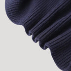 Close-up of a navy blue ribbed knit cardigan with a unique denim collar and button closure.