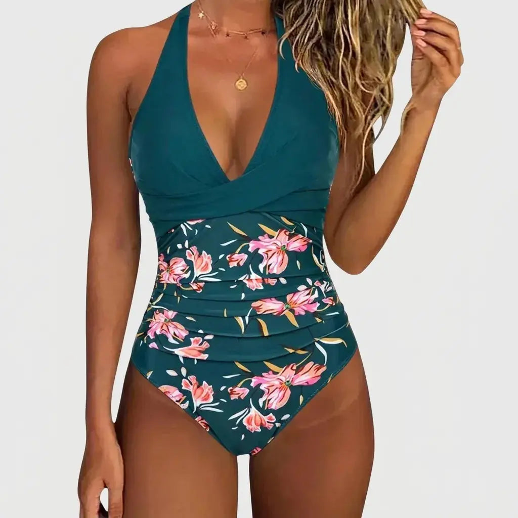 Diepzeegroen badpak met halterhals, bloemenprint en flatterende plooien bij de taille voor een comfortabele pasvorm.