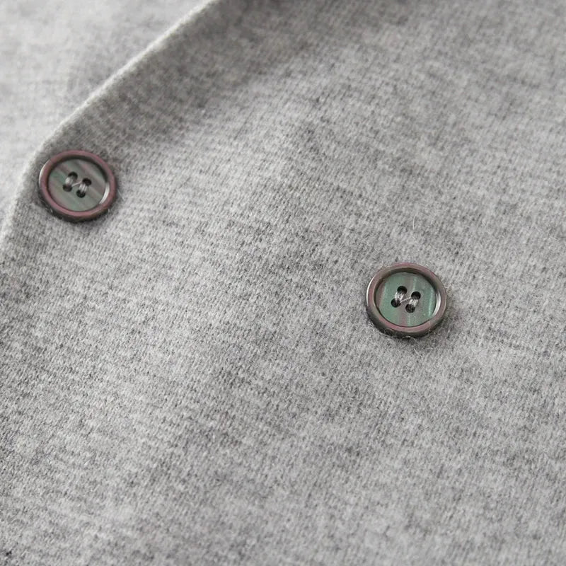 Grijze double-breasted blazer van 100% gekamde cashmere met donkere knoopdetails.