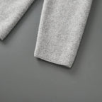 Close-up van een grijze, zachte blazer mouw gemaakt van 100% gekamde cashmere met een verfijnde textuur.