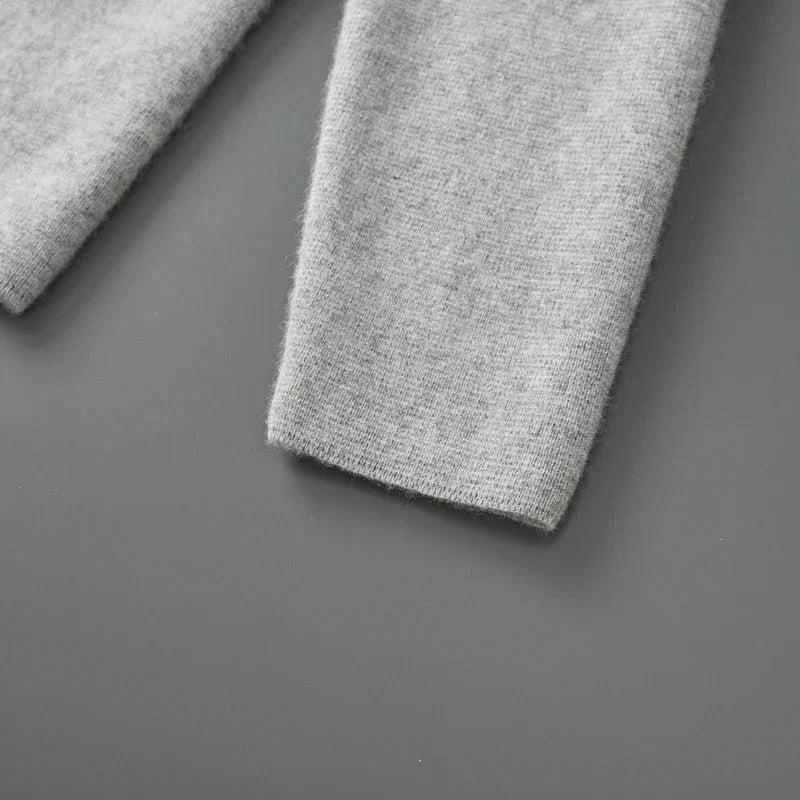 Close-up van een grijze, zachte blazer mouw gemaakt van 100% gekamde cashmere met een verfijnde textuur.
