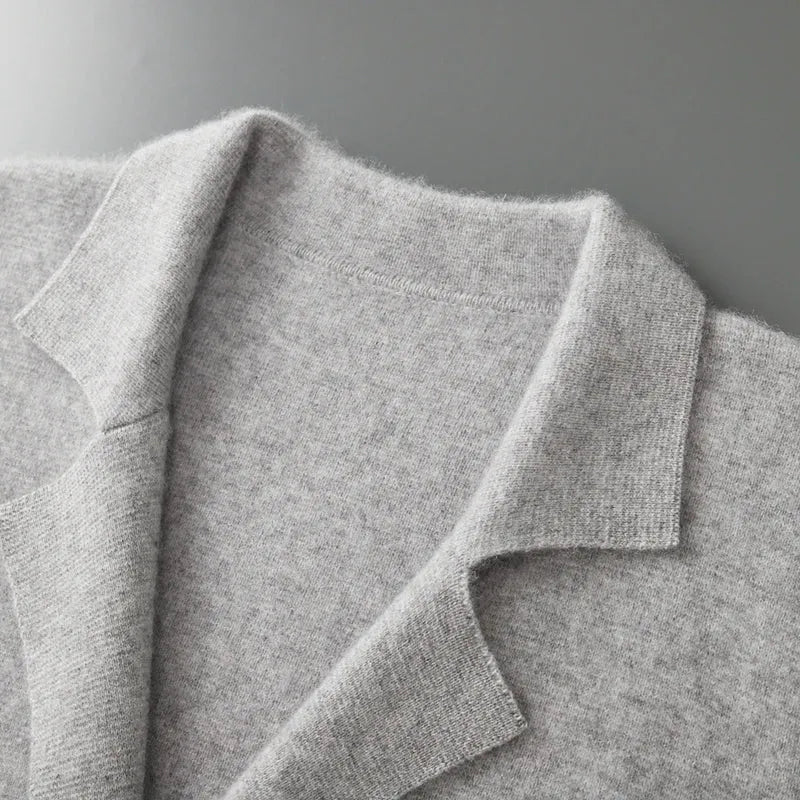 Grijze damesblazer van 100% gekamde cashmere met klassieke reverskraag en verfijnde gebreide textuur.