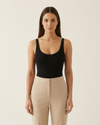 Model draagt de naadloze bodysuit van Miss Madera als top op een high waist pantalon