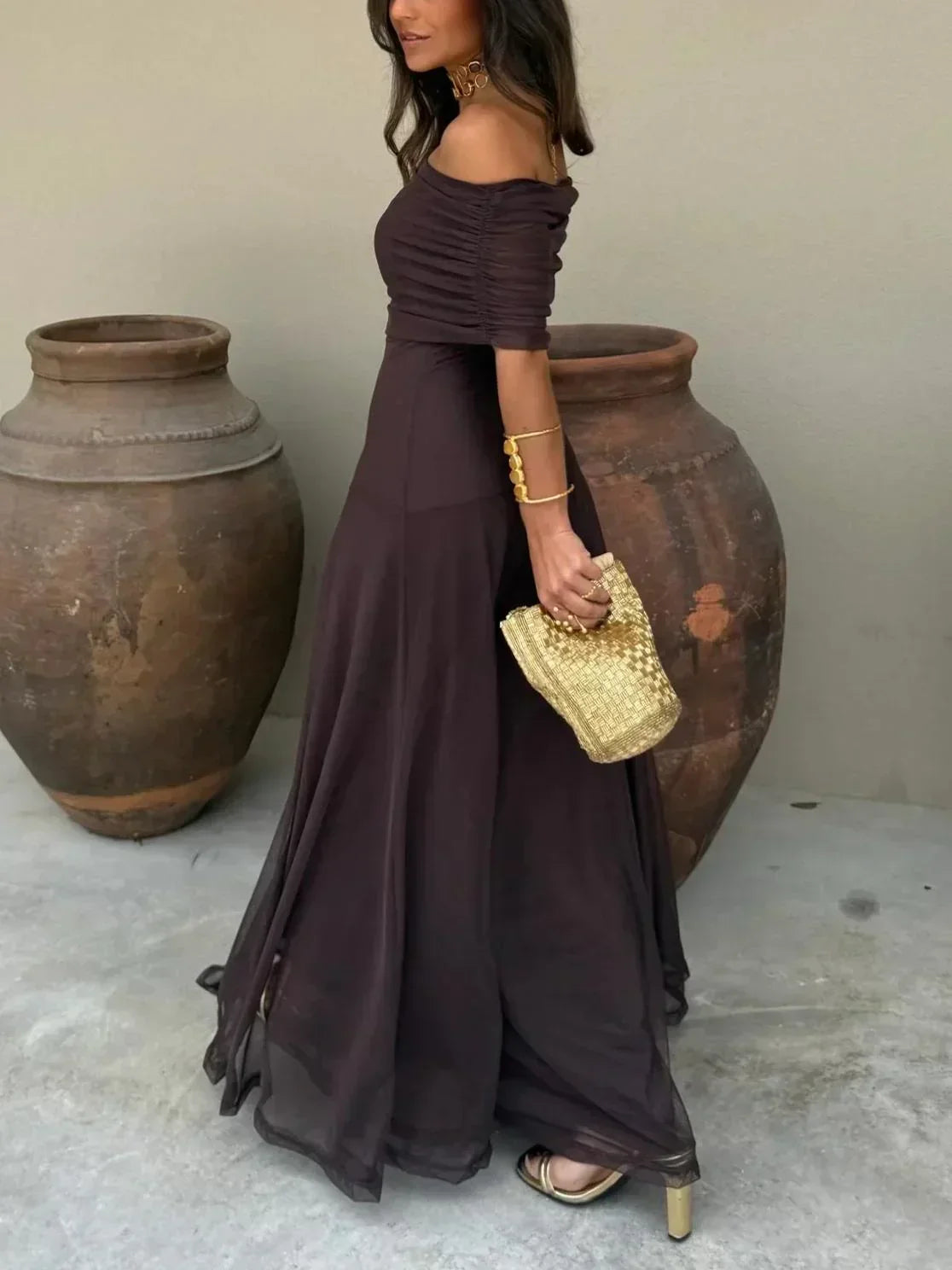 Robe longue chocolat femme, épaules dénudées, en tissu léger avec un design fluide et des détailles élégantes.