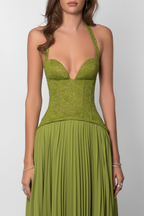 Robe longue verte en tissu plissé avec un corset ajusté, idéale pour des occasions élégantes et décontractées.