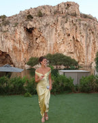 Robe longue jaune à épaules dénudées, en satin, avec pochette assortie, parfaite pour une soirée élégante.