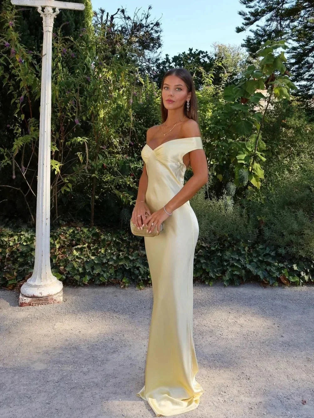 Robe longue jaune à épaules dénudées, en tissu léger, accompagnée d'une pochette en satin, parfaite pour les soirées.